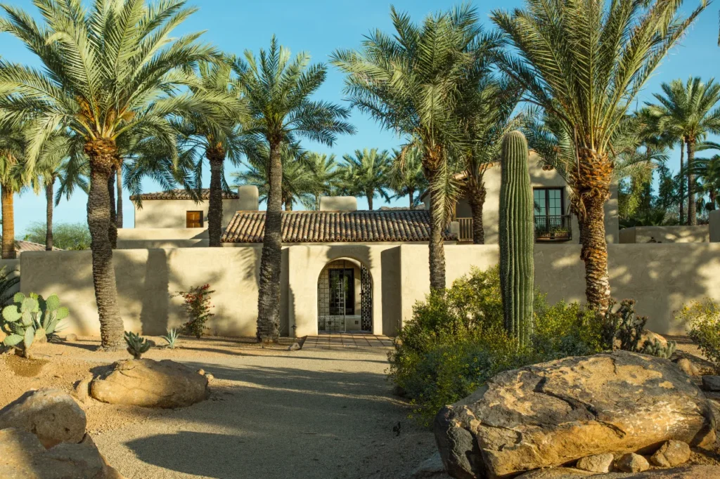 Historic Glaus House featuring historic adobe preservation, arched courtyard entry, and palm grove in Paradise Valley by Spiral Architects